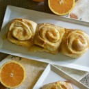 Overhead view of 3 orange sweet rolls on a platter