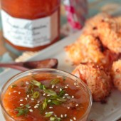 A bowl of sweet and spicy mirabelle golden plum dip with coconut shrimp