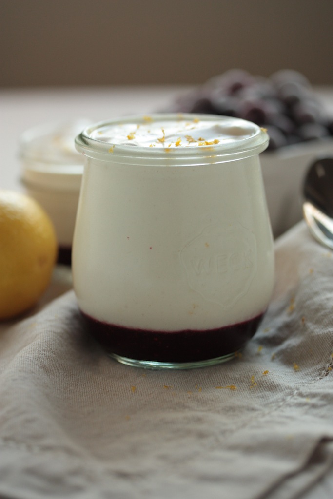Jar of lemon mousse with layer of blueberries in bottom