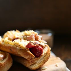 Close-up of a Reuben Hot Dog on a wooden board