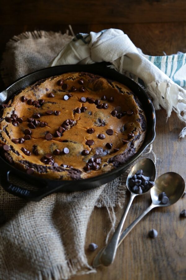 Skillet Brownie with two antique forks and chocolate chips
