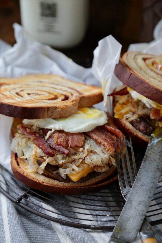 Cinnamon Swirl Loaded Breakfast Sandwich - www.countrycleaver.com Filled with bacon, sausage, hashbrowns and topped with a soft egg! You can't turn down this beast!