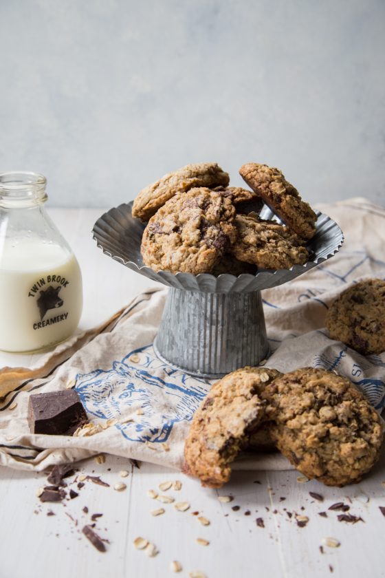 Dark Chocolate Chunk Oatmeal Coconut Cookies on a white background with a milk bottle in the background
