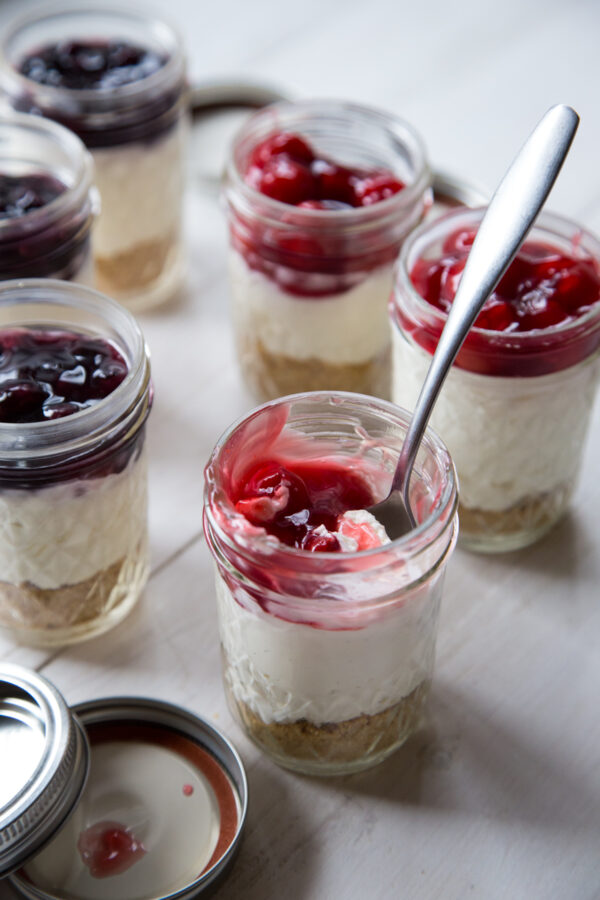 No Bake Cheesecakes In A Jar with cherries and spoon in jar