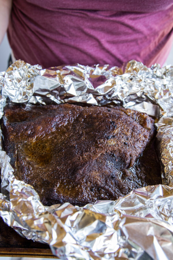 Holding a platter of brisket in foil after it has been smoked