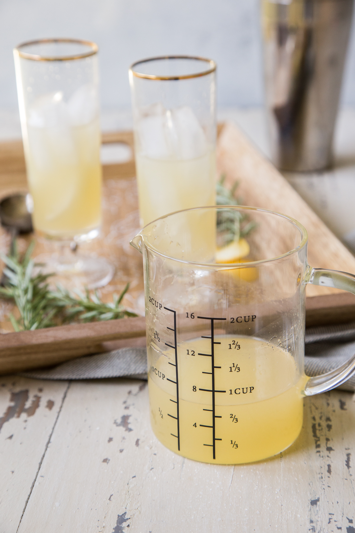 Homemade Rosemary Lemonade Spritzer Cocktail with measuring cup