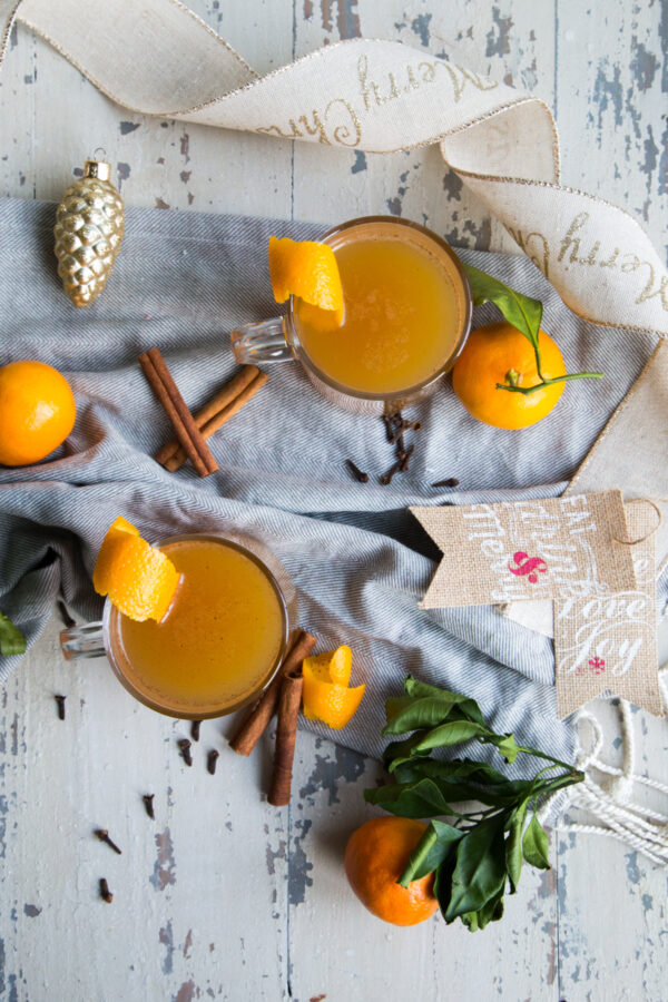 Orange Spiced Apple Cider with ornaments oranges and ribbon