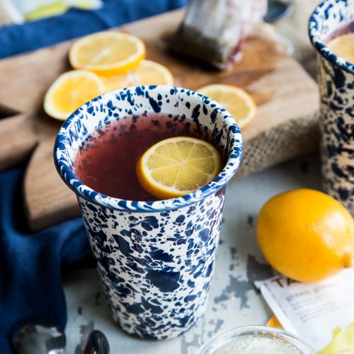 Starbucks Medicine Ball Copycat drink in blue and white mug with lemon slices on a white background