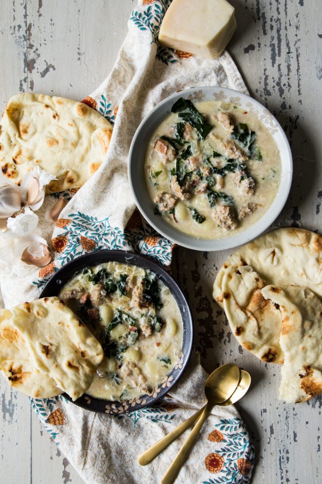 sausage kale and gnocchi soup in two bowls on a white background