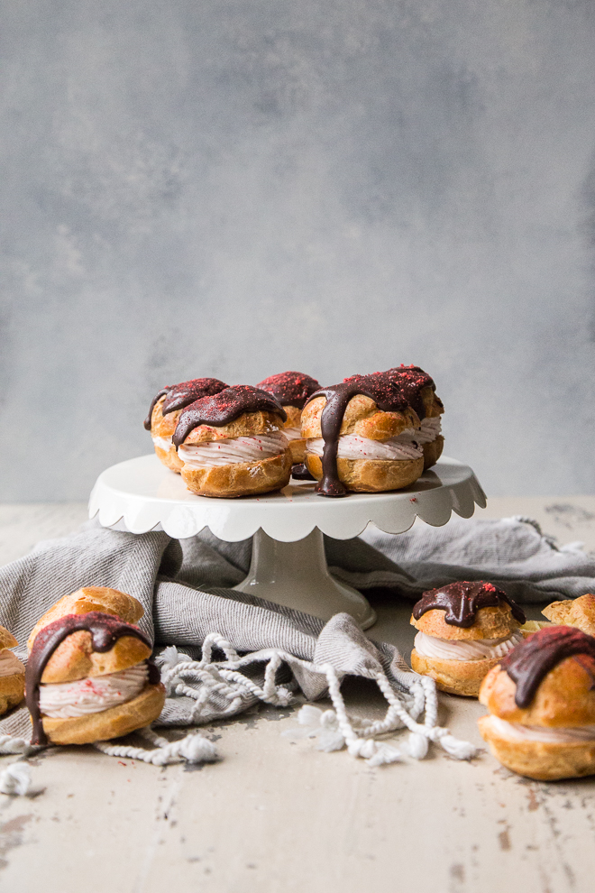 cream puffs on a cake stand with lightly striped napkin