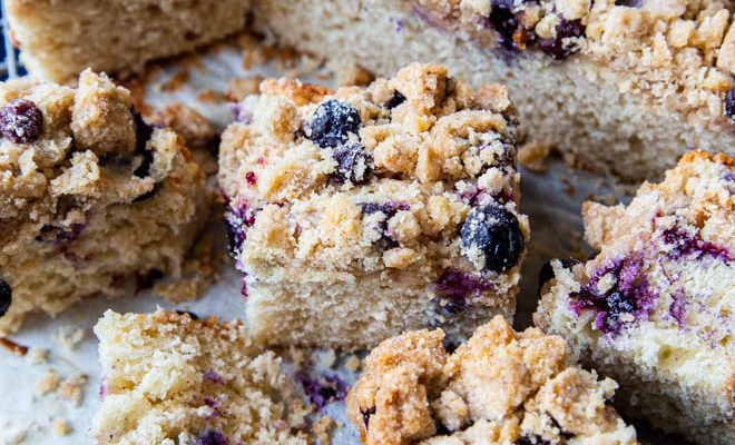 sliced squares of sourdough bluberry coffee cake on a wire rack