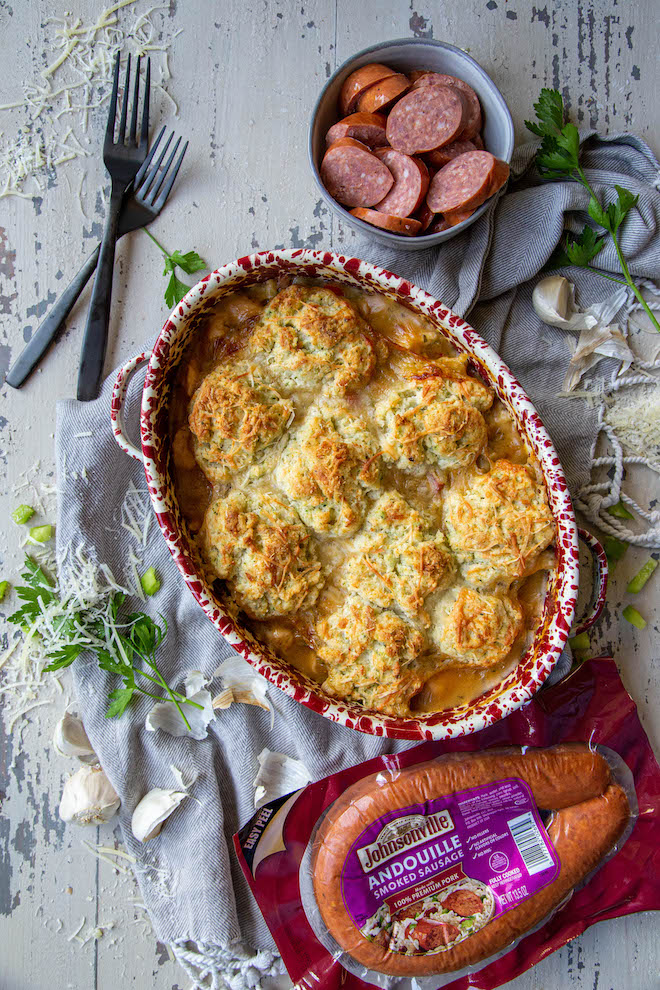 Full on comfort food with andouille sausage and chicken pot pie, topped with cheesy herbed biscuits for an all in one meal! Overhead on white background