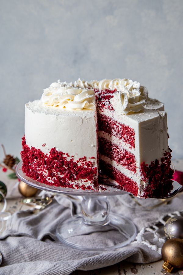Sliced three layer red velvet cake with white swiss meringue frosting