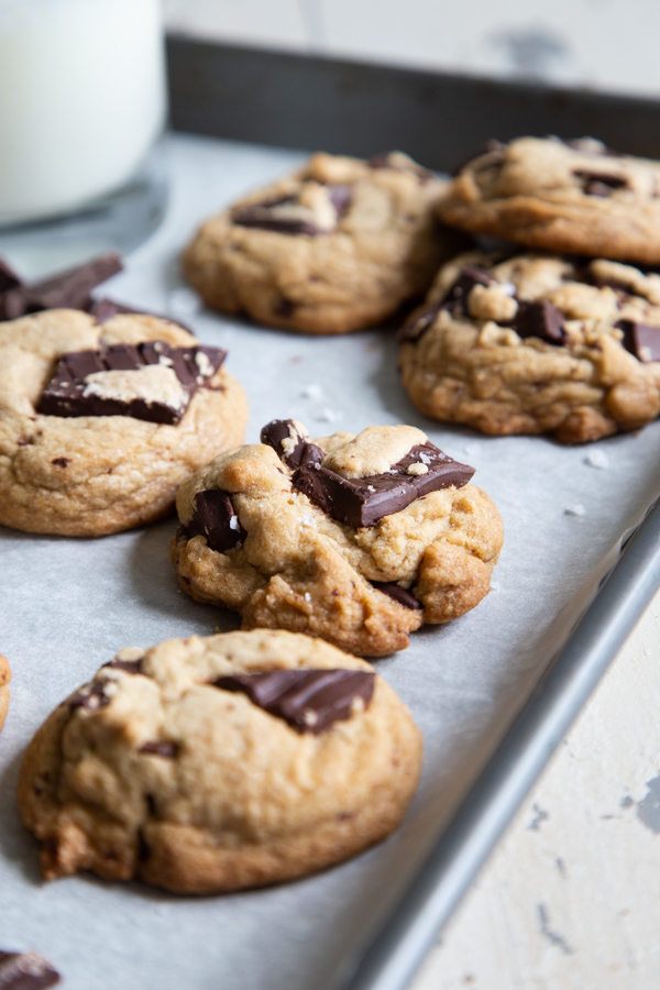 Closeup shot of Bourbon Brown Butter Chocolate Chunk Cookies on parchment lined baking sheet
