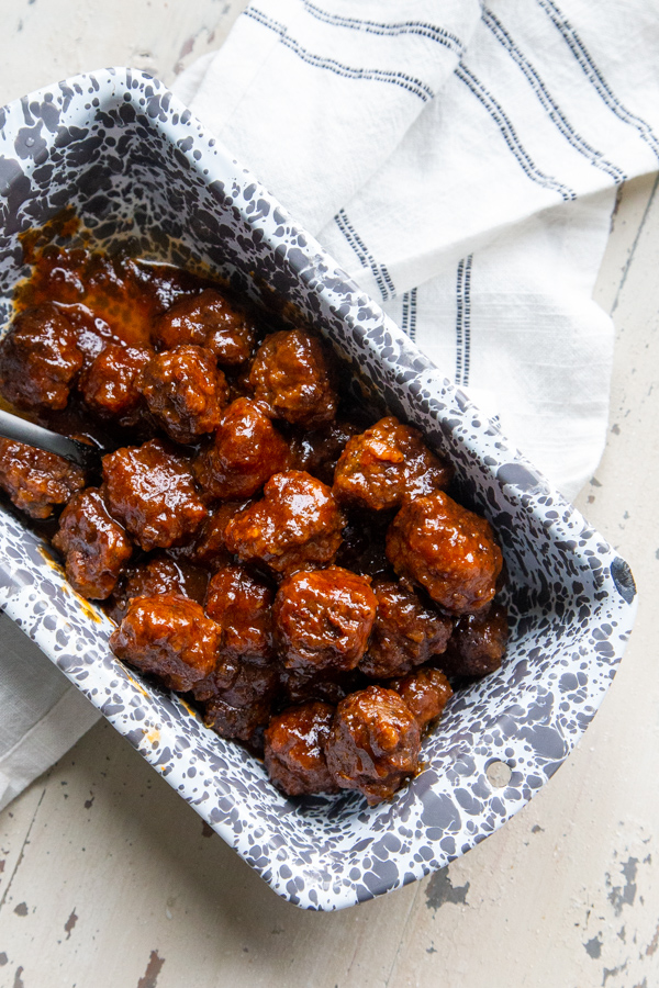 Slow cooker chipotle apricot meatballs in a gray and white loaf pan for serving