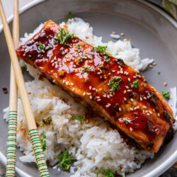 Teriyaki Herb Glazed Salmon Fillets over white rice with chopsticks